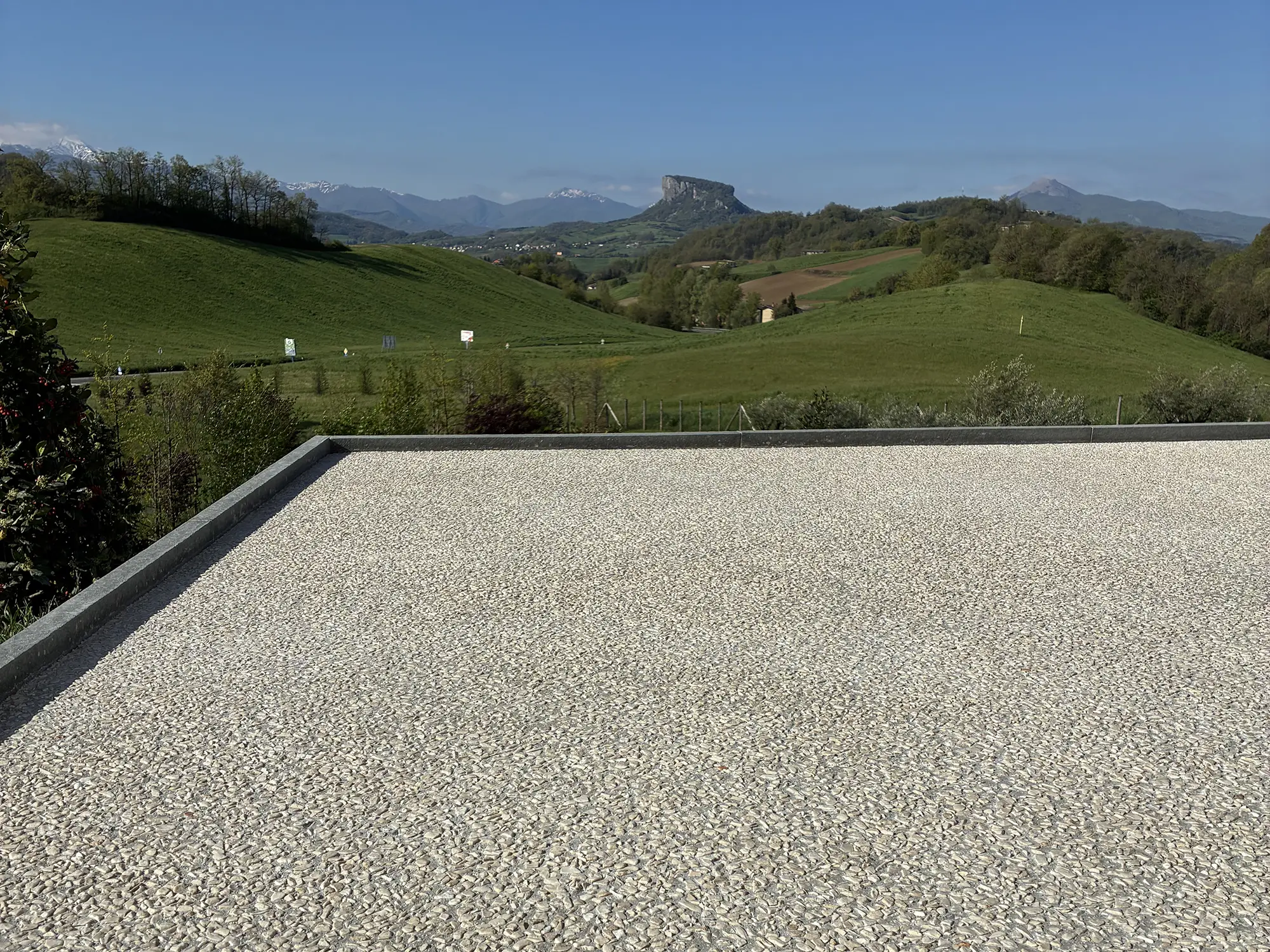 Pavimentazione in calcelstruzzo e ghiaietto lavato con sullo sfondo un paesaggio dell'appennino reggiano